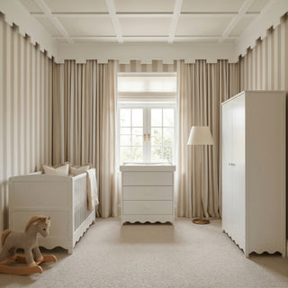 Nursery with a crib, dresser, and wardrobe, large window with curtains, and a rocking horse toy on the floor.
